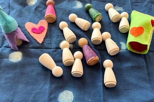 a blue background with wooden peg dolls and valentine hearts