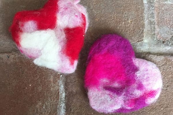 two multi-colored hearts on a brick background