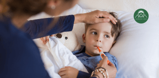 When Does Fever in Children Require Medicine? A Doctor’s Advice mother taking the temperature of a young boy with a fever