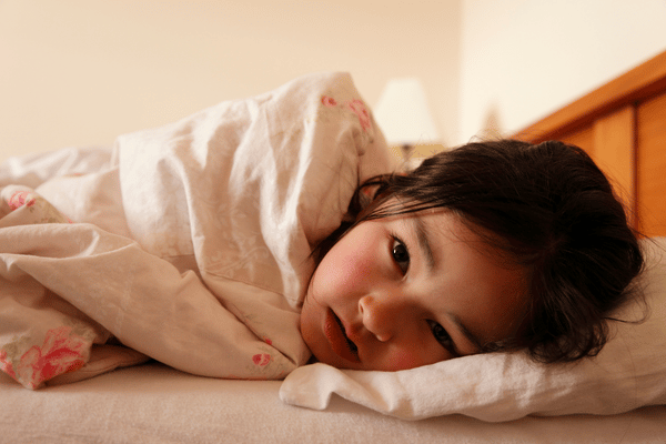 sick child lying in bed