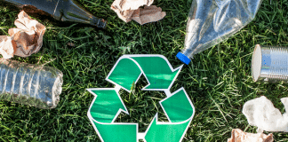Teaching My Kids About Recycling Recycling symbol with garbage on grass.