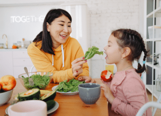 The Best Vermont Spring Foods You Can’t Miss a woman feeding a little girl fresh salad greens