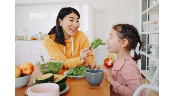 The Best Vermont Spring Foods You Can’t Miss a woman feeding a little girl fresh salad greens