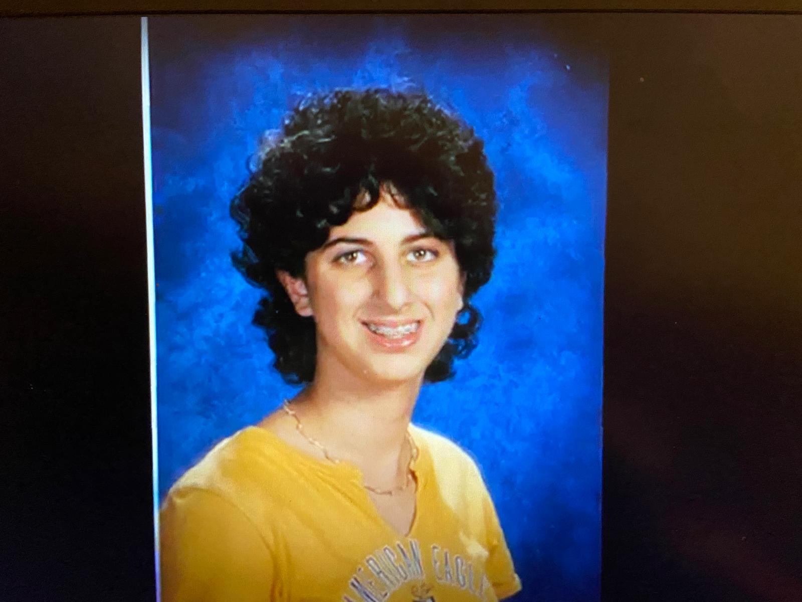 Davida's class photo when she was in 7th grade. She has short and puffy hair while it is growing out. She was being bullied during this time in her life.