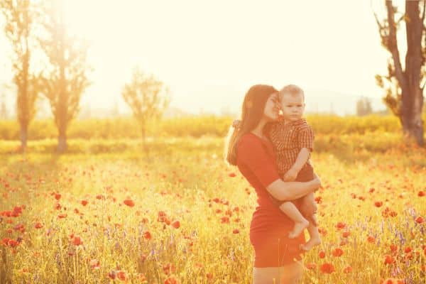 mother and child in flower field pressure of modern motherhood