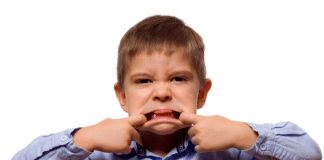 5 Ways I’ve Applied First Time Parenting Lessons to Baby Number Two Young boy sticking his tongue out.