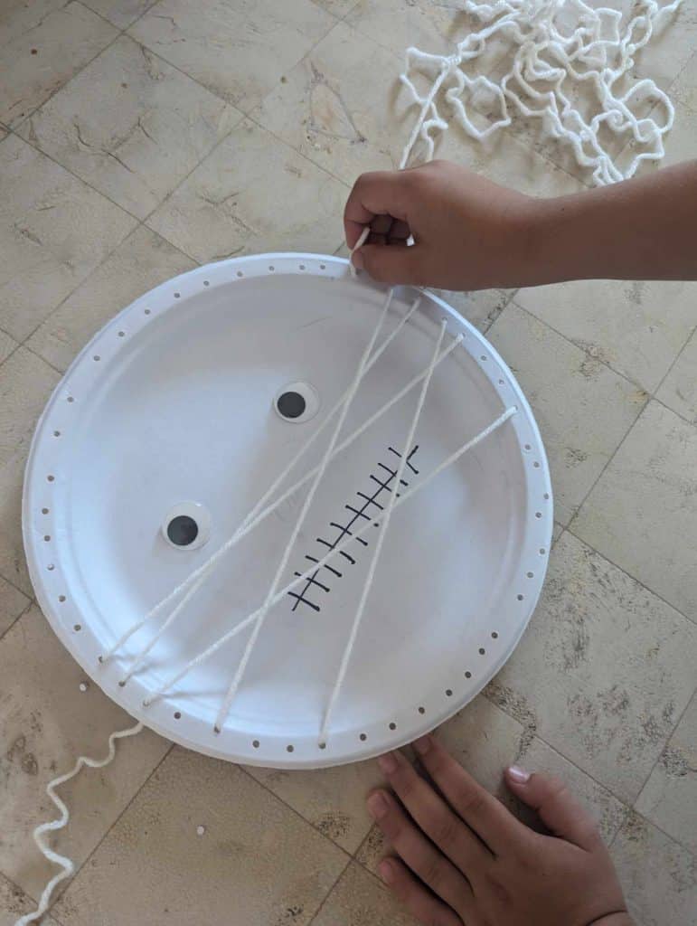 threading yarn in a paper plate