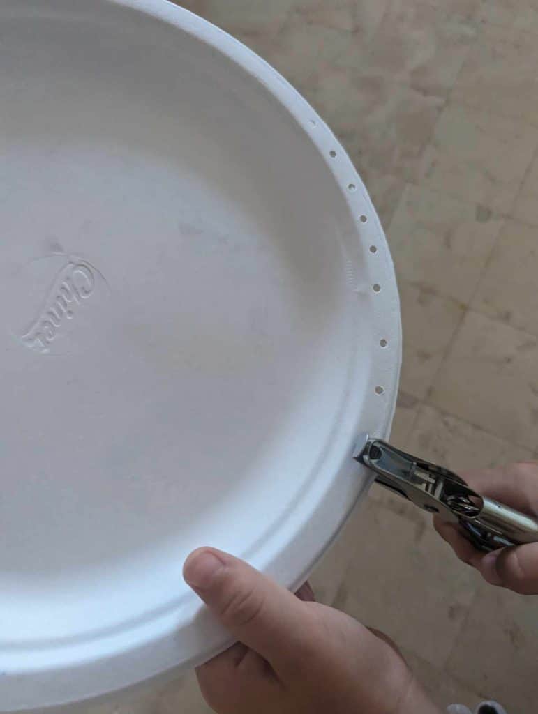 punching holes in a paper plate