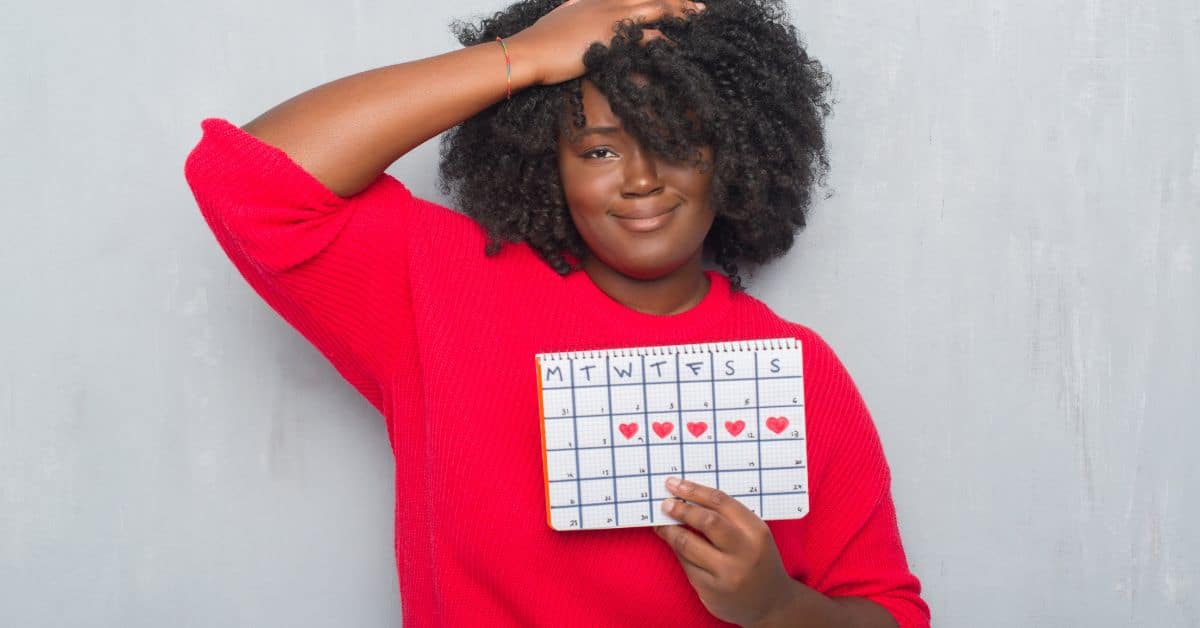 a woman with a calendar in her hands is it menopause