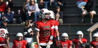 4 Reasons Youth Football Is What Kids Need Now Youth football player in a red jersey. Photo by Doug Whitmore.