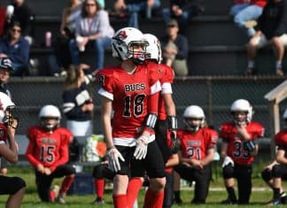 4 Reasons Youth Football Is What Kids Need Now Youth football player in a red jersey. Photo by Doug Whitmore.