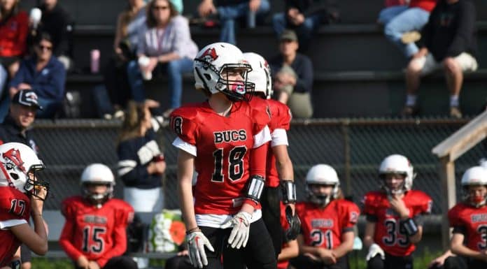 4 Reasons Youth Football Is What Kids Need Now Youth football player in a red jersey. Photo by Doug Whitmore.