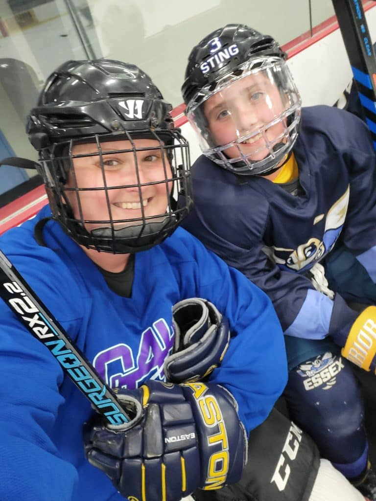 mother and son wearing blue hockey gear and smiling