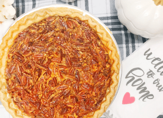 Our Favorite Southern Thanksgiving Pecan Pie Recipe This image shows a baked pecan pie on a table with a tea cloth.