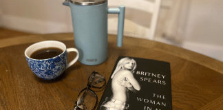 Parenting Dos and Don’ts From the Britney Spears Memoir, The Woman in Me The Britney Spears memoir on a table with a French press and a cup of coffee.