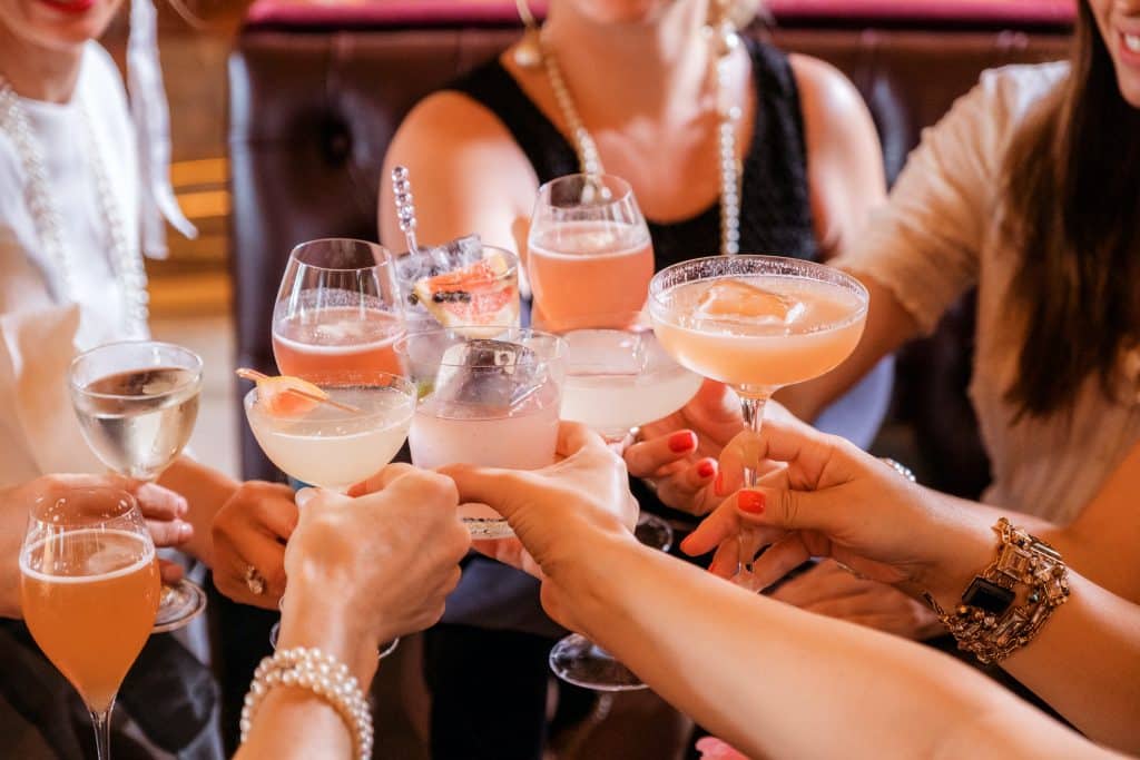 a group of people raise their glasses of holiday mocktails infused with healing herbs from Traditional Chinese Medicine