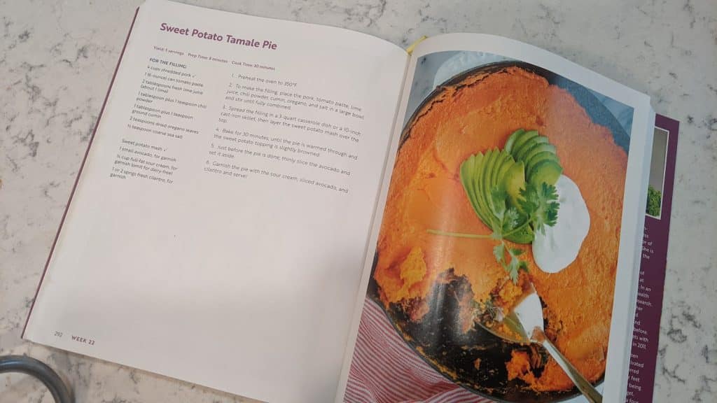a cookbook opened up on a countertop with a sweet potato pie on the page