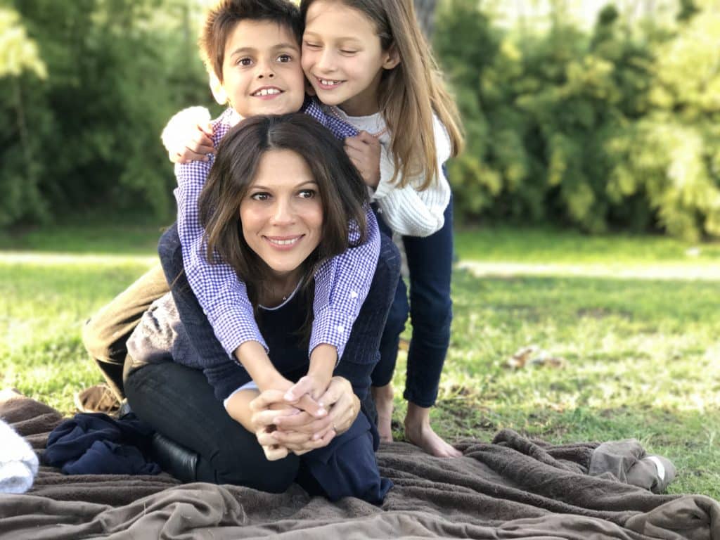 Mom and two kids on a blanket on the grass