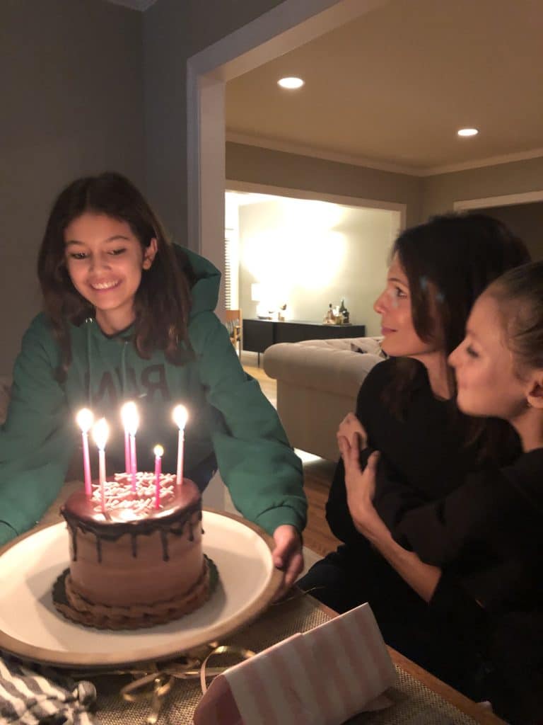 Family gathered around a birthday cake