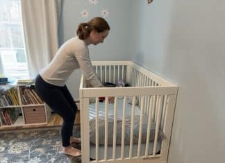 6 Simple Ways Parents Can Address and Prevent Back Pain Woman reaching into her child's crib with proper posture.