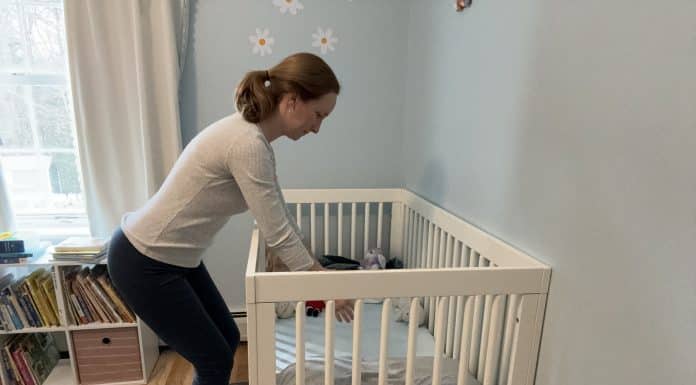 6 Simple Ways Parents Can Address and Prevent Back Pain Woman reaching into her child's crib with proper posture.