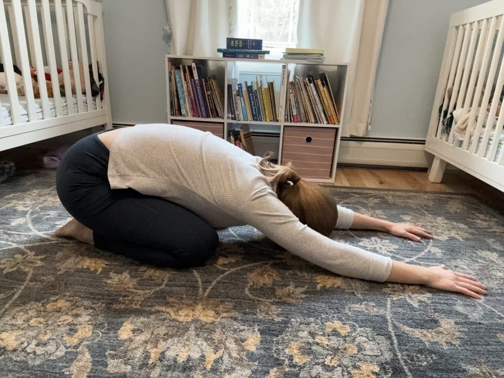 woman in a child's pose to prevent back pain and injury