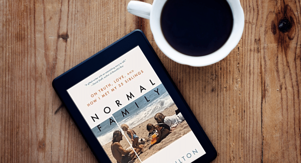 Normal Family, a book, on a table with a cup of coffee