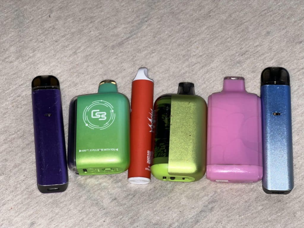 A line of colored e-cigarettes or vape pens