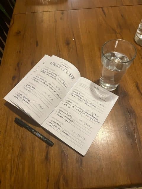 bullet journal and a glass of water on a table