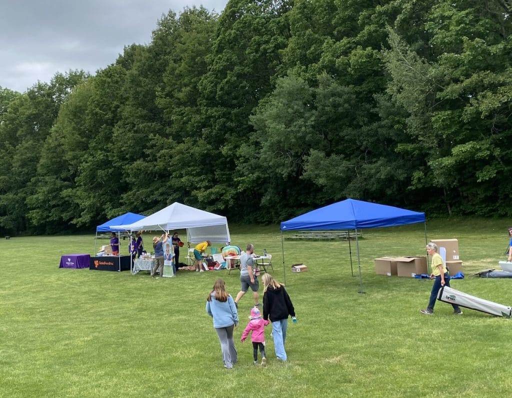 Setting up Essex Pride in 2023. Author's kid, wearing a pink jacket, explores.