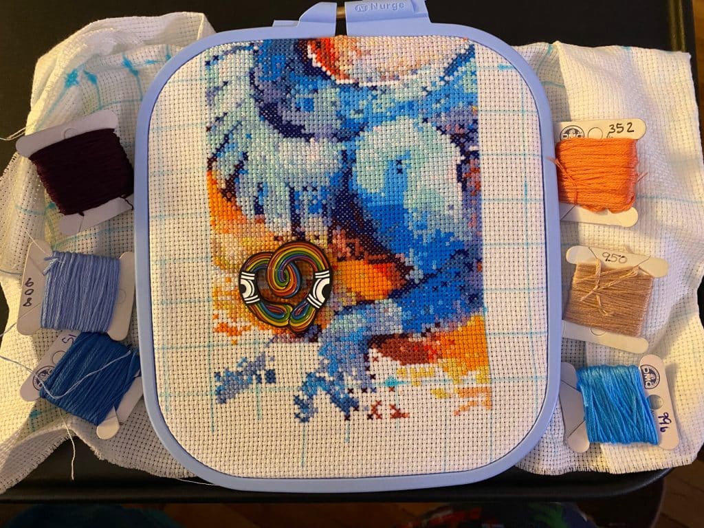 An in-process cross stitched dragon.