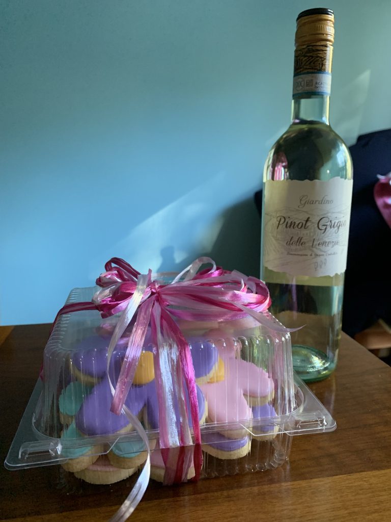bottle of white wine and a box of frosted cookies