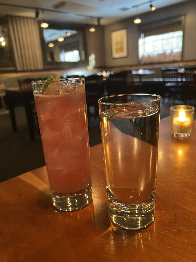 mixed alcoholic drink and a glass of water
