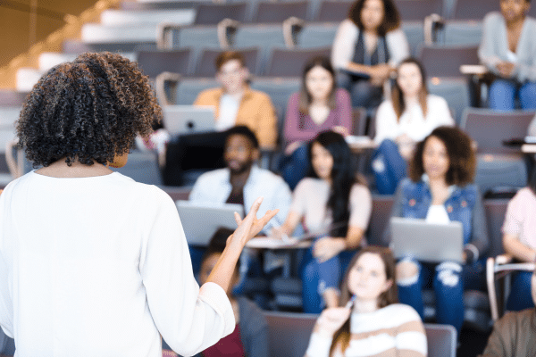 college professor lecturing to a hall of students