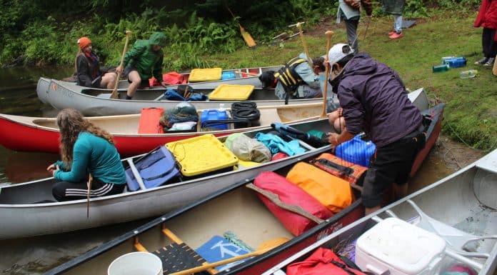 Canoes are loaded to bring campers to Water Wanderings wilderness camp rustic camp site