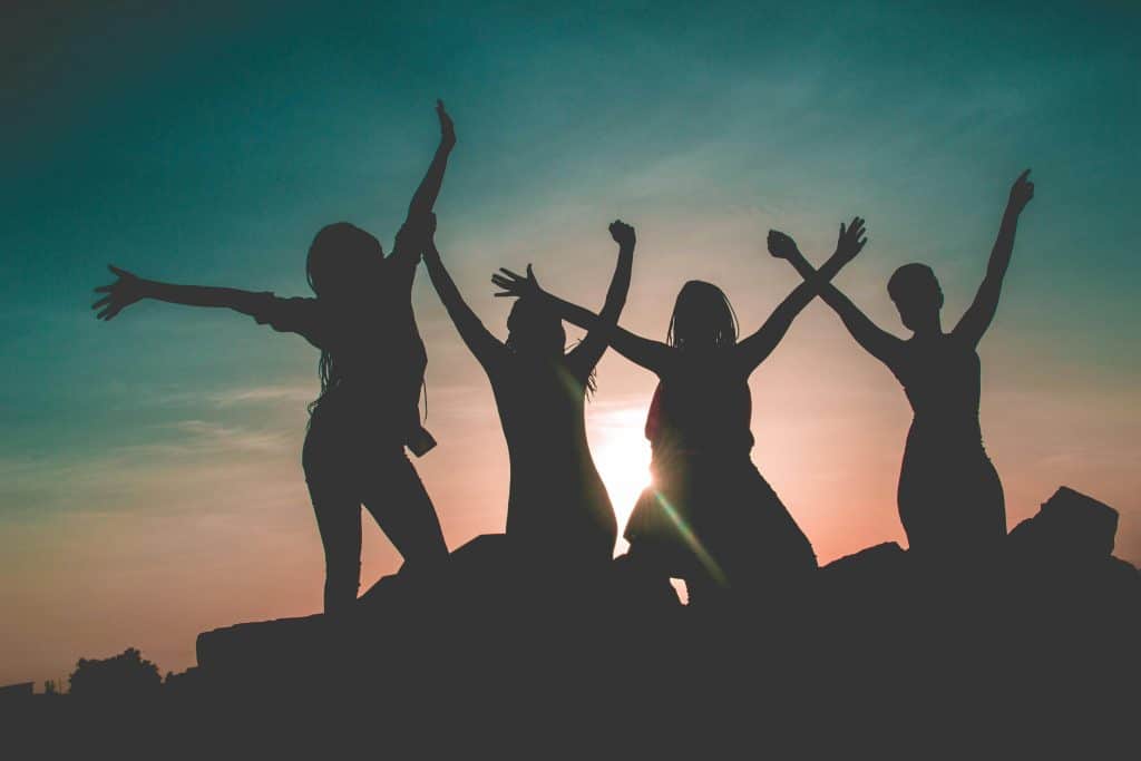 four women, backlit against the sunset.