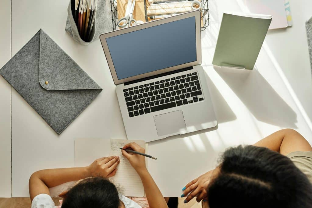 parent and child working on homework in front of a computer