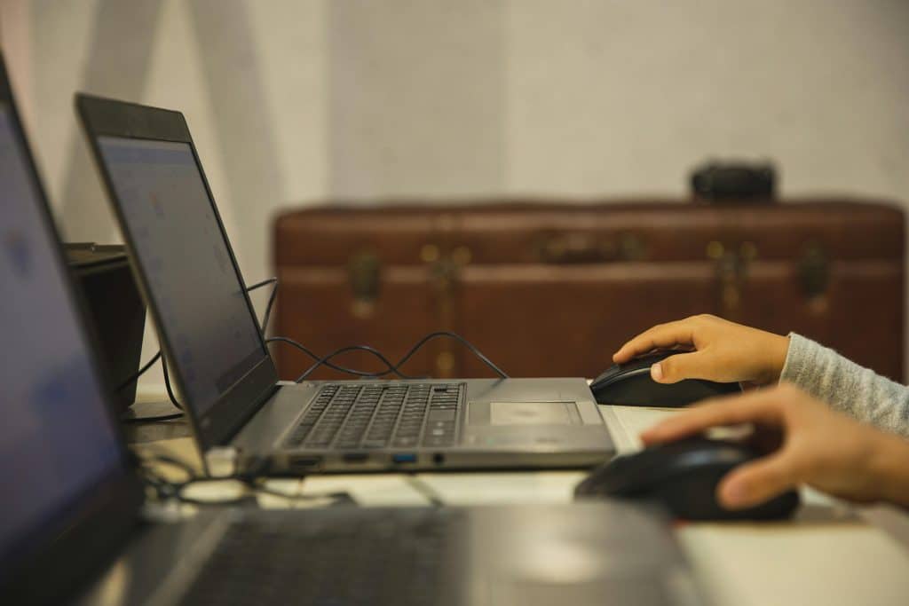 young hands on computer mouses while teens use computers