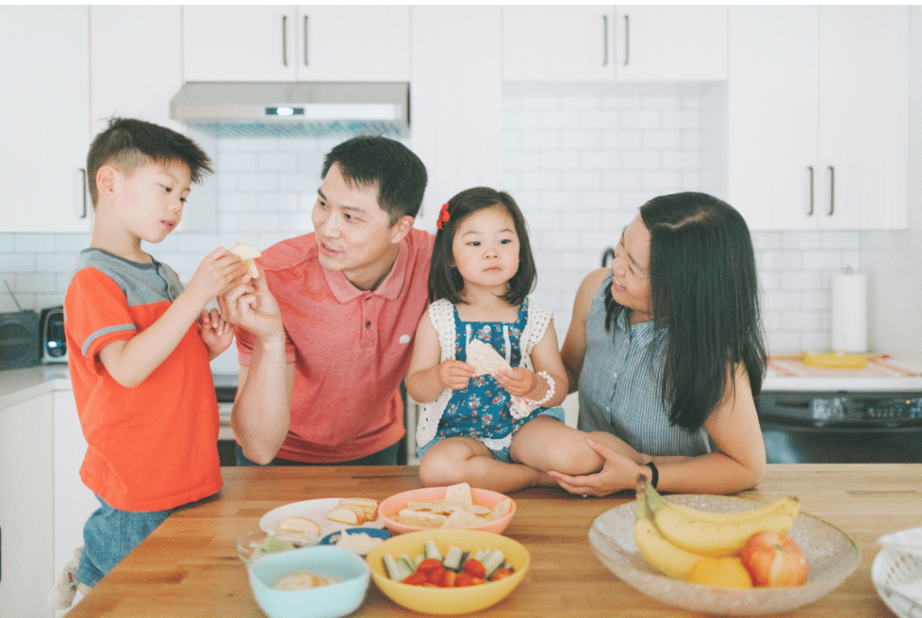 family of four in the kitchen making dinner