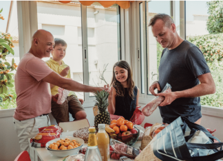 4 Easy and Delicious Dinner Recipes for Busy Families a family of four at the dining table with an assortment of food