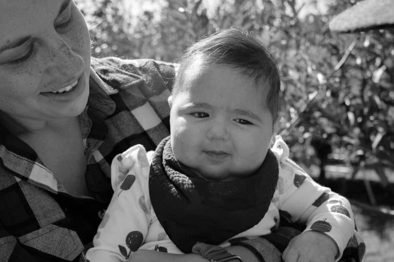 the author holding their youngest daughter in an apple orchard