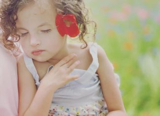 Writing My Way Back to Myself: Healing After Profound Loss beautiful young girl being held. Her eyes are closed.