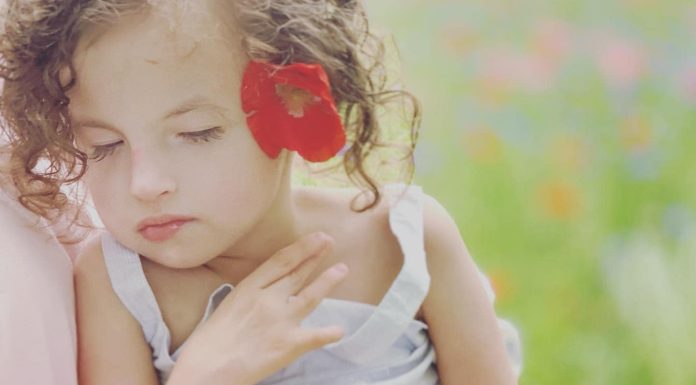 Writing My Way Back to Myself: Healing After Profound Loss beautiful young girl being held. Her eyes are closed.