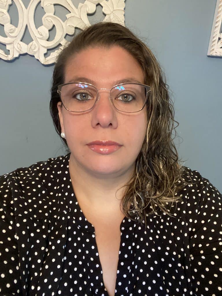 with wavy light brown hair and glasses