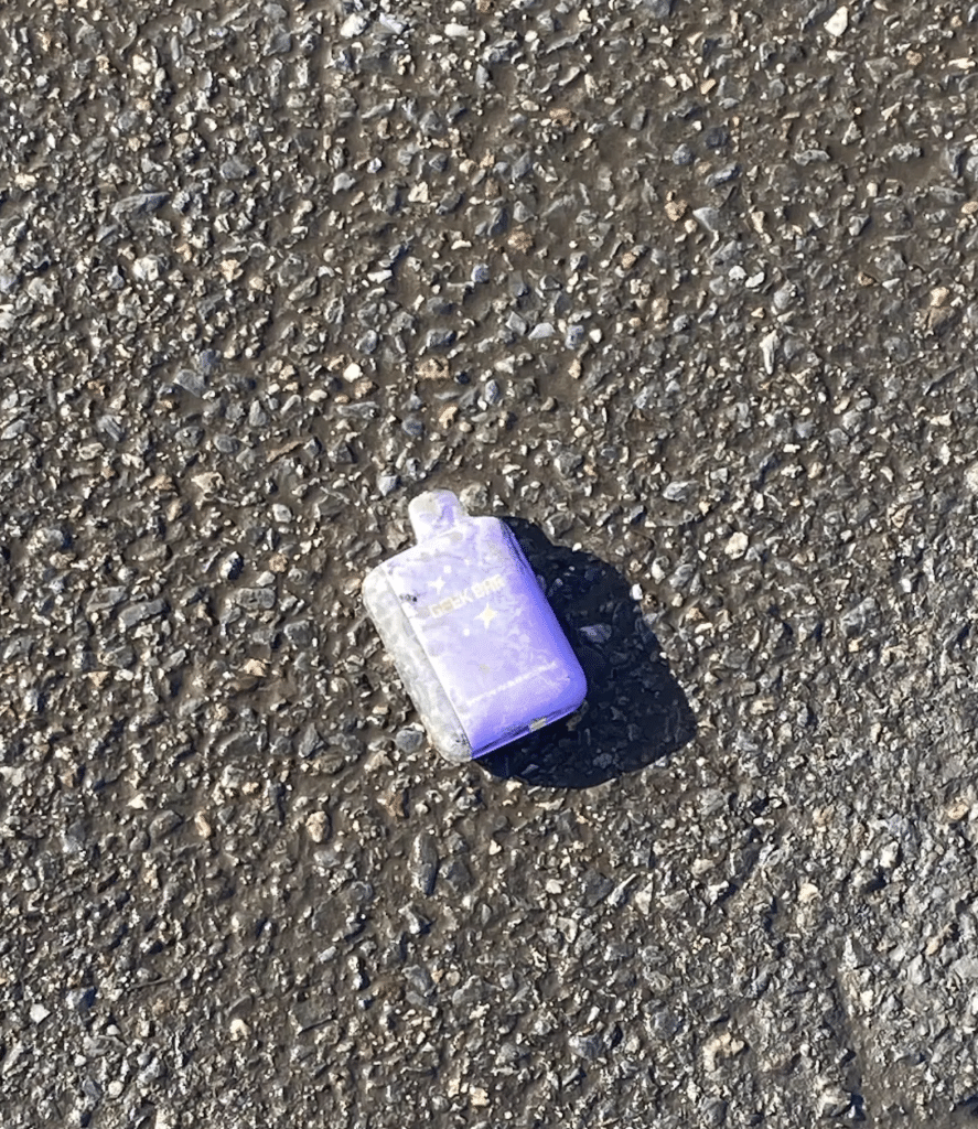 battered purple vape on the ground