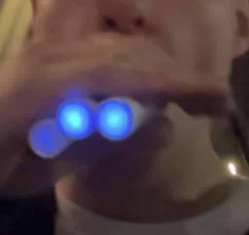 person using a vape to smoke flavored tobacco