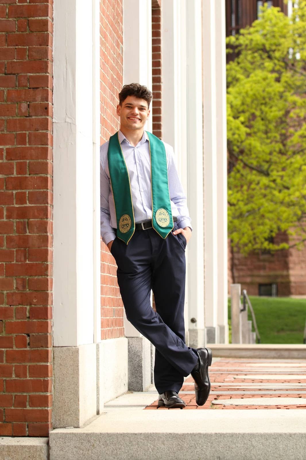 Young man at college graduation, smiling at the photographer