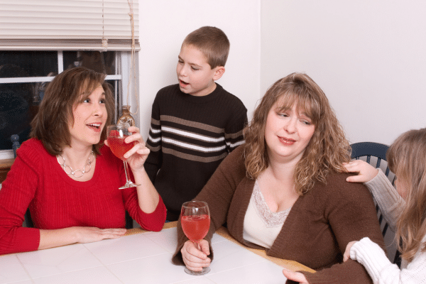 moms drinking wine while their kids pester them.