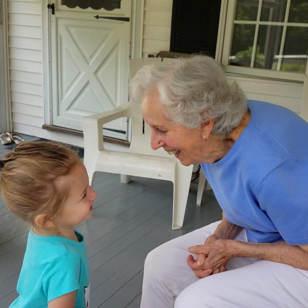 A smiling, overjoyed grandmother with a laughing child