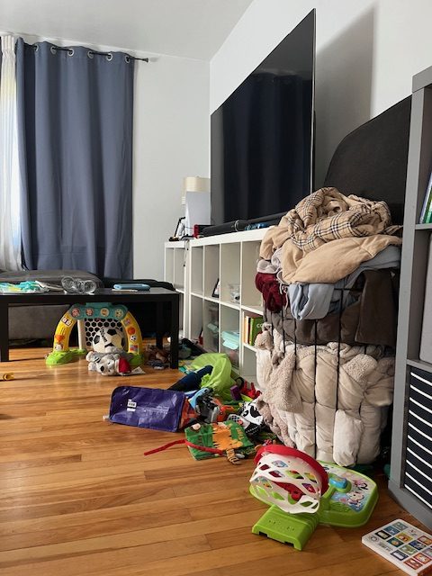 disorganized living room, bursting with kids' toys and signs of a happy life
